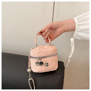 Close-up of pink quilted vanity bag featuring camellia charm and silver chain strap