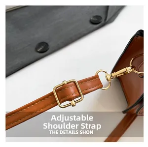 Close-up of adjustable brown leather shoulder strap with gold buckle and clip fasteners