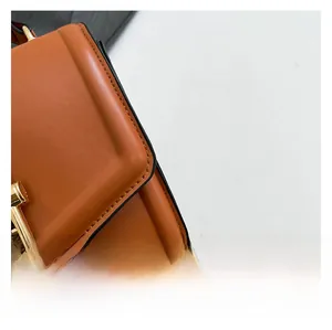 Close-up of premium brown faux leather texture with neat stitching and gold hardware