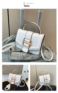 Detail view of white PU leather crossbody bag with a large gold rectangular metal buckle