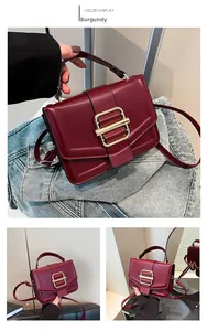 Detail of burgundy PU leather crossbody bag featuring gold buckle and adjustable strap