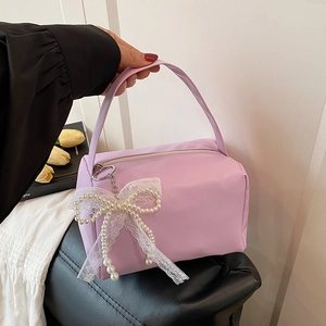 Chic lavender purple handbag featuring a delicate white lace bow and pearl pendant charm