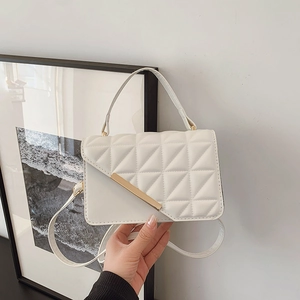 White quilted crossbody bag with gold buckle hardware and elegant top handle strap