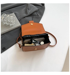 Interior view of tan crossbody square bag showing black lining and storage capacity