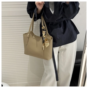 Detail of khaki soft leather tote bag with stylish printed scarf on the handle