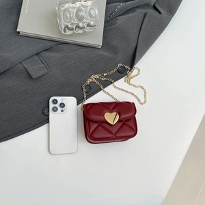 Chic red mini crossbody bag with quilted pattern and gold heart lock in a flat lay setup