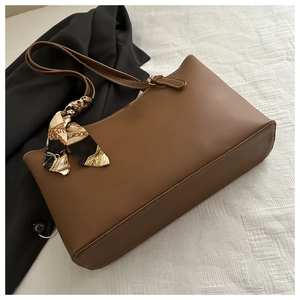 Detail showing vintage brown soft leather tote bag with silk scarf and white stitching