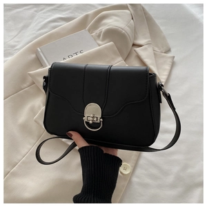 Detail of black matte leather shoulder bag featuring a unique silver ring metal clasp