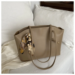 Detail of khaki tote bag with matte faux leather texture and decorative geometric scarf