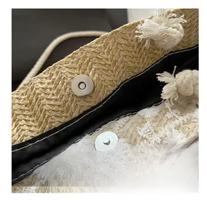 Détail du fermoir magnétique sur le sac en paille avec broderie en dentelle blanche
