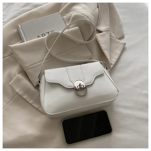 Detail of white PU leather crossbody bag featuring wave-edge flap and silver D-ring buckle