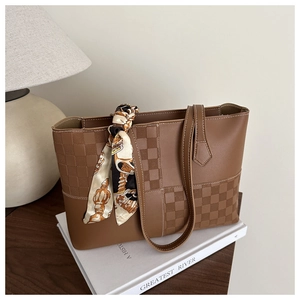 Detail of brown tote bag featuring checkered texture and vintage silk scarf accessory
