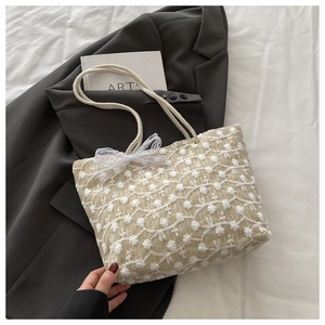 Chic beige straw tote bag featuring white floral daisy embroidery and ribbon details