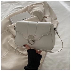 Close-up of white leather crossbody bag featuring an elegant silver oval twist lock