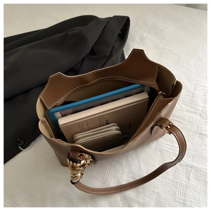 Top view of large brown leather tote bag showing spacious interior with laptop and scarf