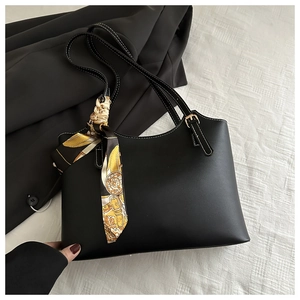 Detail of vintage soft black leather tote with contrast white stitching and printed silk scarf