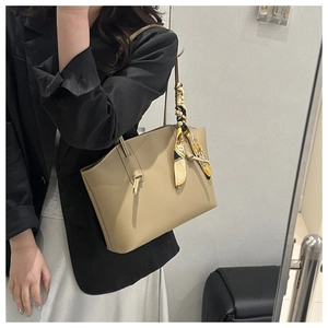 Borsa tote beige in ecopelle con foulard in seta decorativo indossata da una modella