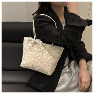 Détail d'un sac en dentelle avec broderie florale et nœud sur fond sombre