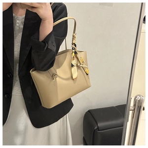 Dettaglio della borsa tote in pelle beige con foulard decorativo in seta sul manico