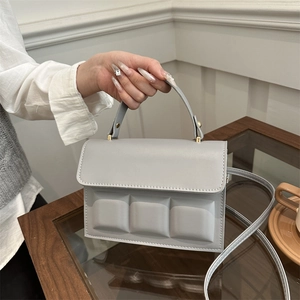 Light blue square handbag with quilted chocolate pattern and elegant gold hardware