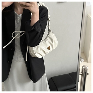Detail of creamy white pleated hobo bag with ruched shoulder strap and triangle logo