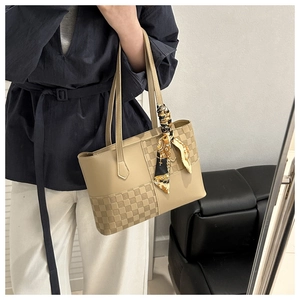 Detail of beige tote bag with checkered woven texture and a decorative floral silk scarf