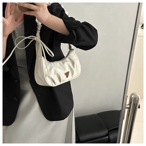 Detail der weißen Lackleder-Schultertasche mit Falten und goldenem Dreiecksdekor
