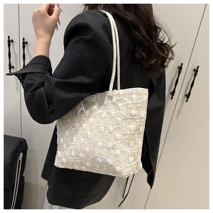 Detailed embroidery on white woven tote bag with rope handles for summer style