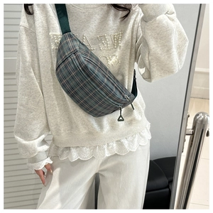 Close-up of a plaid crossbody bag featuring vintage tartan pattern and double zippers