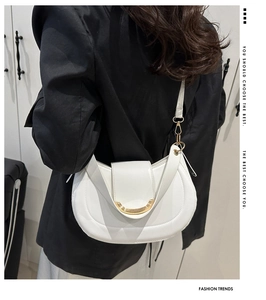 Détail du sac bandoulière blanc en demi-lune avec ornement en métal doré