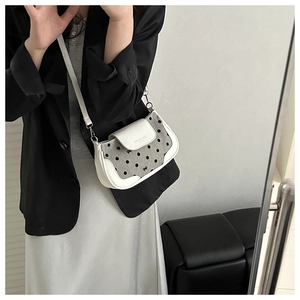 Détail de la bordure en cuir blanc et du tissu à pois noirs sur ce sac à bandoulière