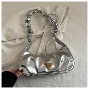 Detail of silver metallic pleated handbag with a gold triangular logo and elastic strap