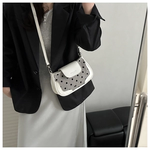 Détail du sac bandoulière en cuir blanc et tissu à pois gris avec sangle réglable