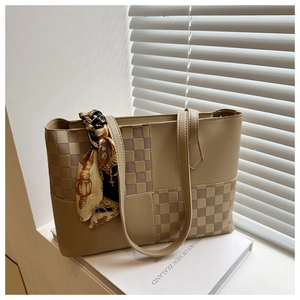 Detail of contrast checkered tote bag with vintage silk scarf on a book