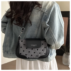 Sac en tissu à pois avec imprimé nœud et bordure en cuir porté à l'épaule par un mannequin