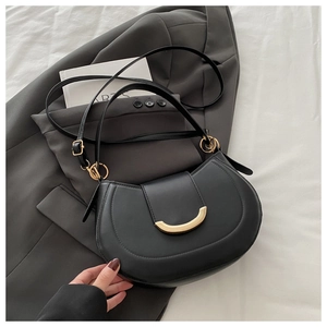 Detail of black leather crescent bag with elegant gold crescent buckle and shoulder strap