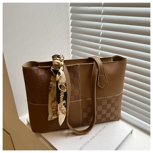 Detail of checkered pattern stitching on brown tote bag with silk scarf handle ornament