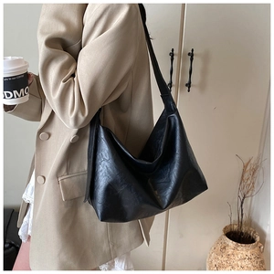 Detail of matte black PU leather shoulder bag with soft texture and hobo silhouette