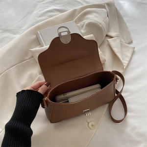 Brown vintage PU leather shoulder bag with silver clasp showing internal storage space