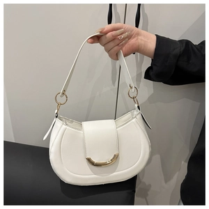 Detailed shot of white leather crescent bag with golden metal buckle and shoulder strap