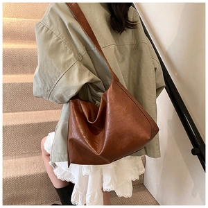 Detail of soft brown PU leather tote bag with vintage texture and minimalist wide strap