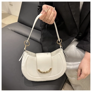 Detail of white leather underarm bag with gold metal buckle and elegant flap closure