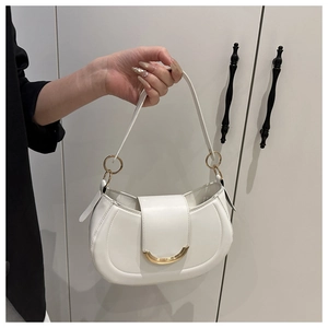 Detailed close-up of white semi-circle shoulder bag with gold metallic ring and curved trim