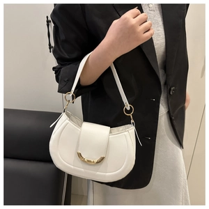 Détail d'un sac demi-lune blanc avec accent en métal doré et texture de cuir