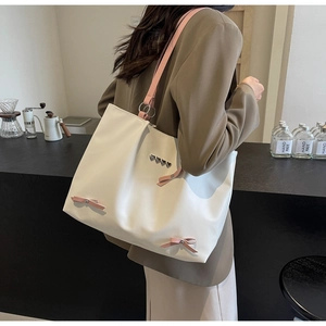Fashionable large capacity tote bag with pink bows and metal heart details shown on shoulder