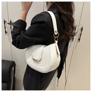 Détail d'un sac porté épaule blanc en demi-lune avec boucle en métal doré et cuir mat
