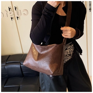 Detailed view of dark brown vintage tote bag with soft PU leather texture and shoulder strap