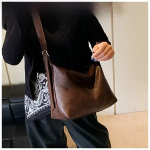 Deep brown oversized crossbody bag with soft vintage leather texture and wide strap