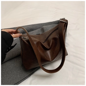 Detail of dark brown vintage hobo bag with textured leather and adjustable wide strap