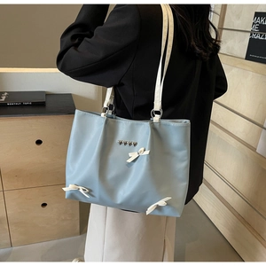 Light blue ballet style tote bag with heart rivets and bow detailing on the shoulder